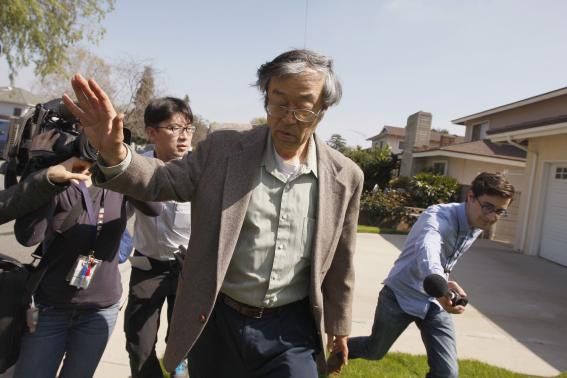 Satoshi Nakamoto is surrounded by reporters as he leaves his home in Temple City, California